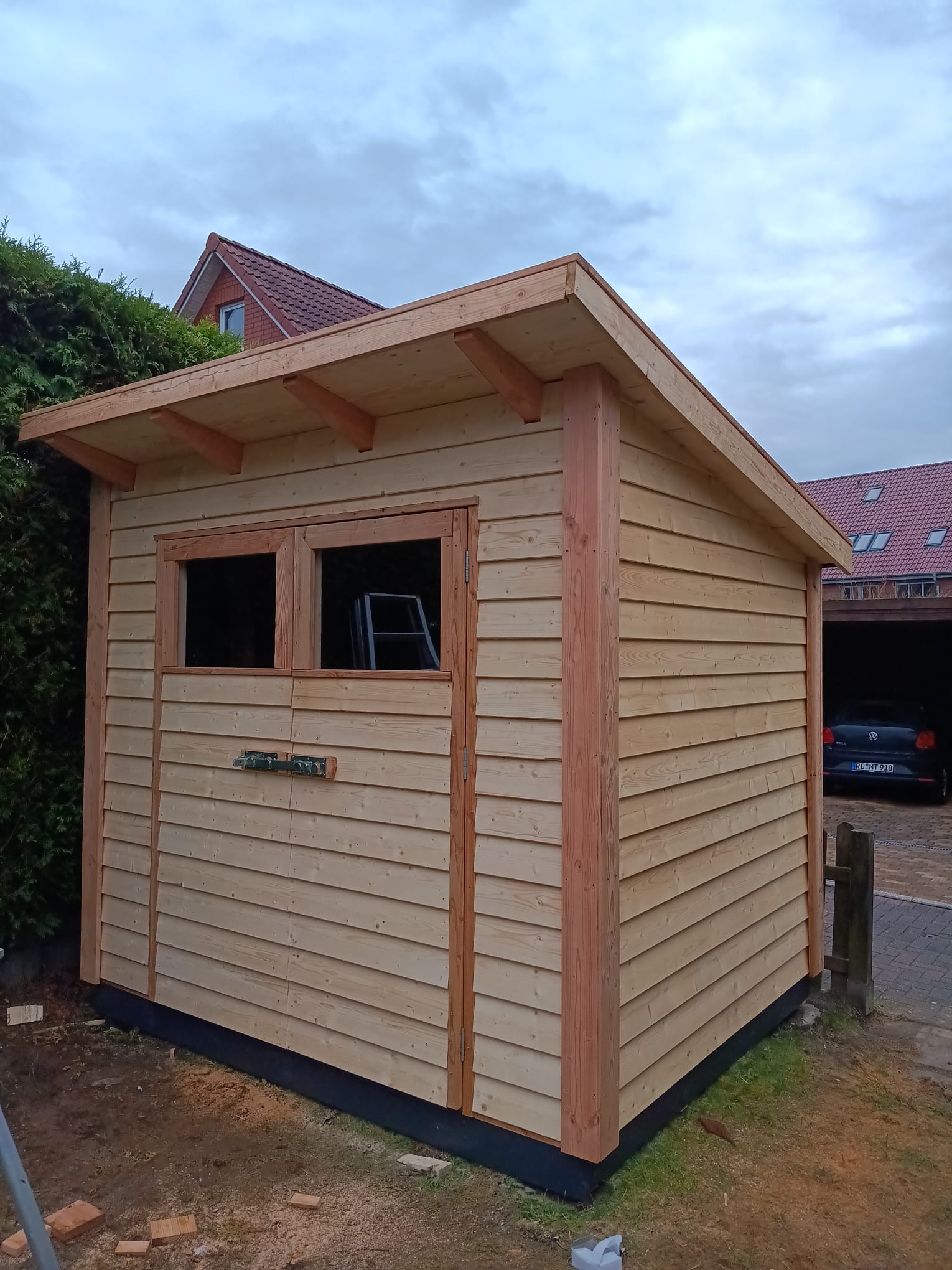 Kleines neu gebautes Holzhaus Kleines neu gebautes Holzhaus mit zwei Fenstern und Flachdach.
