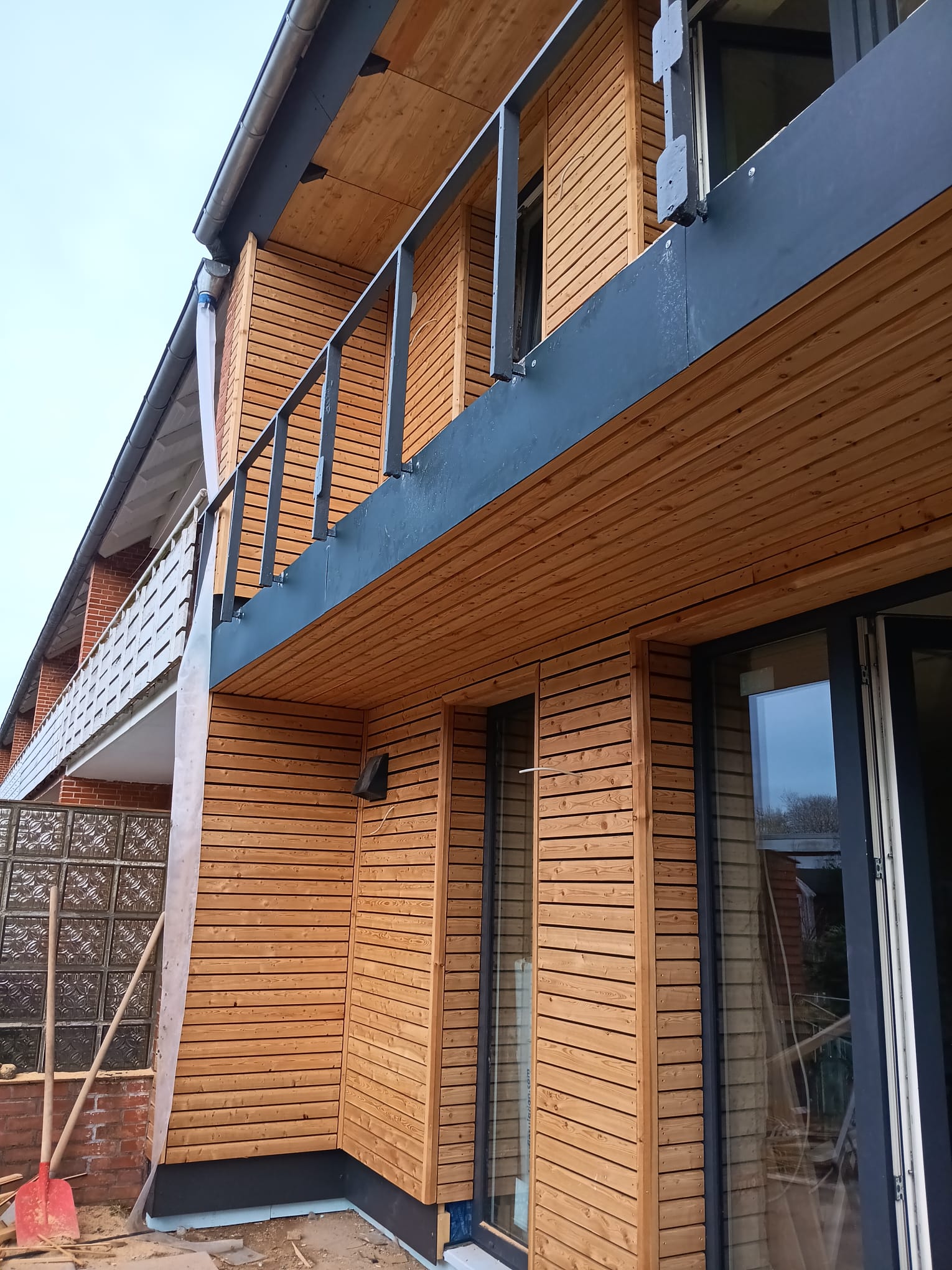 Moderne Holzfassade Moderne Holzfassade eines zweigeschossigen Hauses mit Balkon.